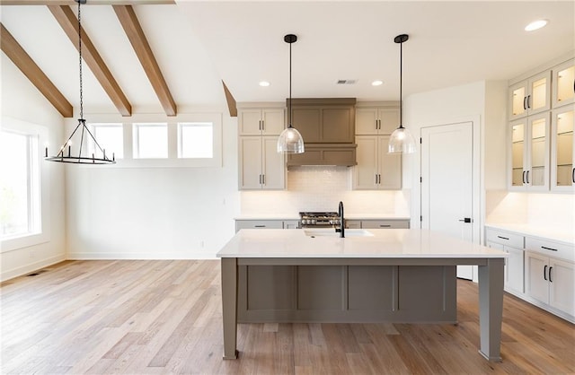 kitchen with a sink, light countertops, light wood-style flooring, recessed lighting, and decorative backsplash