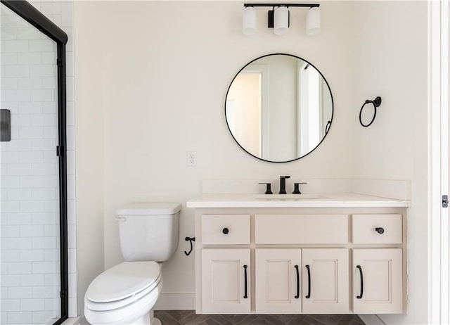 full bathroom featuring toilet, tiled shower, and vanity