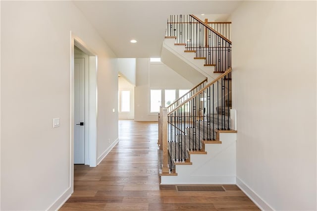 stairway with recessed lighting, wood finished floors, visible vents, and baseboards