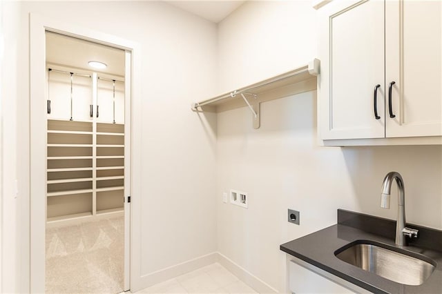 washroom featuring hookup for a washing machine, hookup for an electric dryer, light carpet, a sink, and cabinet space