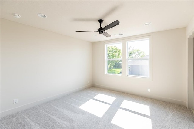 spare room with recessed lighting, light colored carpet, visible vents, a ceiling fan, and baseboards