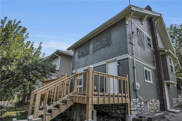 rear view of property featuring a wooden deck