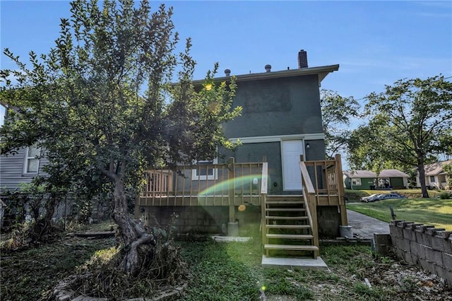 rear view of property with a wooden deck and a yard