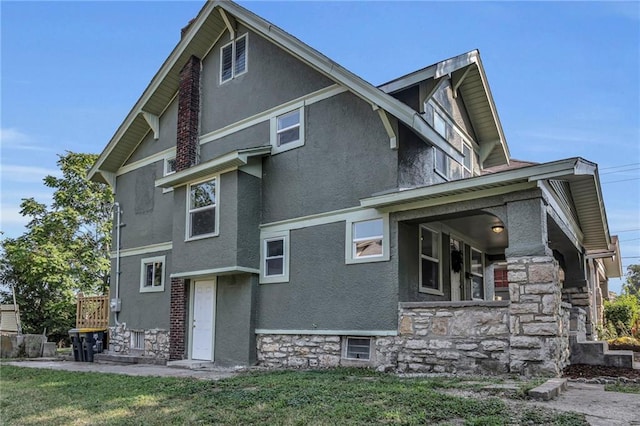 rear view of house featuring stucco siding and a yard