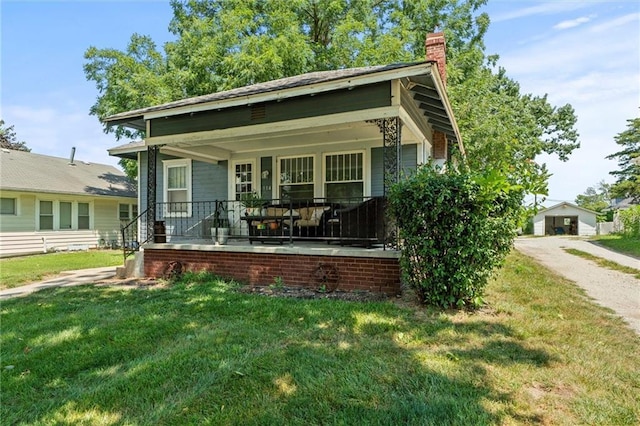 314 E Lexington St, Richmond, MO 64085 - bungalow with a chimney, a front yard, and covered porch
