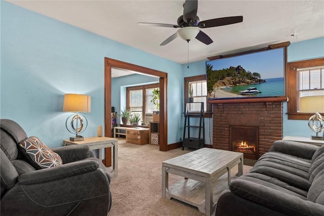 carpeted living room with a fireplace and ceiling fan