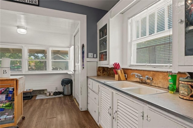 314 E Lexington St, Richmond, MO 64085 - kitchen featuring decorative backsplash, light countertops, dark wood finished floors, white cabinetry, and a sink