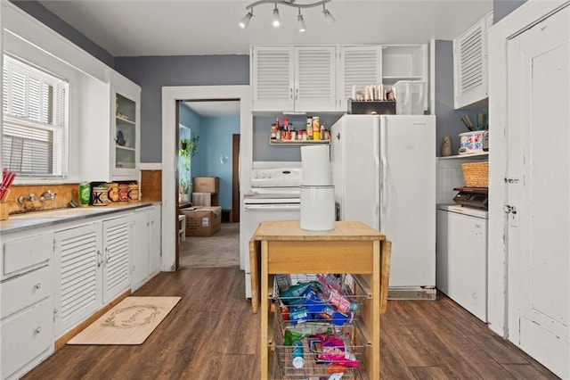 kitchen featuring washer / dryer, dark wood-type flooring, white appliances, and white cabinets