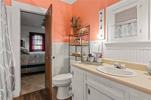 bathroom featuring vanity, wood-type flooring, ceiling fan, and toilet