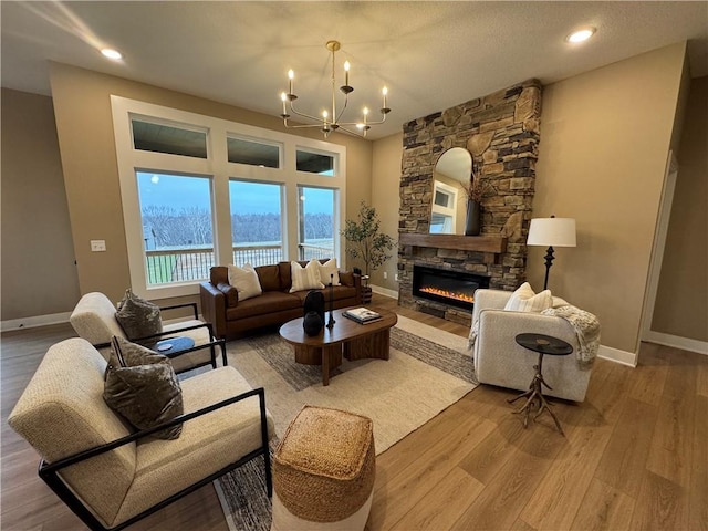 16700 NW 124th St, Platte City, MO 64079 - living room featuring a water view, light hardwood / wood-style flooring, a textured ceiling, a fireplace, and a chandelier