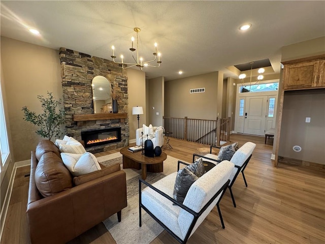 16700 NW 124th St, Platte City, MO 64079 - living room with hardwood / wood-style floors, a stone fireplace, and an inviting chandelier