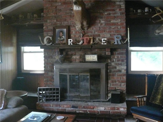 living room featuring brick wall and a fireplace