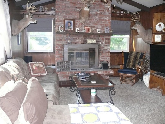 living room with carpet floors, a fireplace, lofted ceiling with beams, and a healthy amount of sunlight