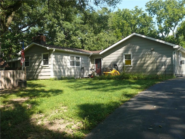 ranch-style home featuring cooling unit and a front yard