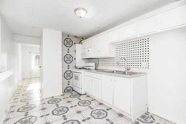 kitchen with light tile patterned flooring, sink, white cabinetry, and white appliances