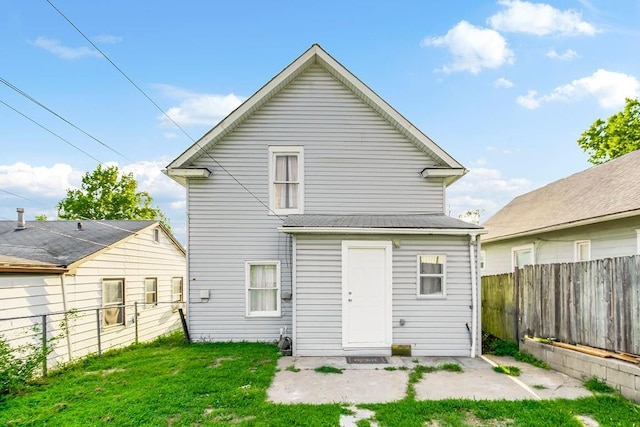 back of property featuring a lawn