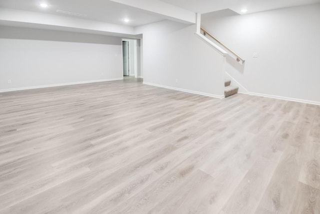 basement with light hardwood / wood-style flooring