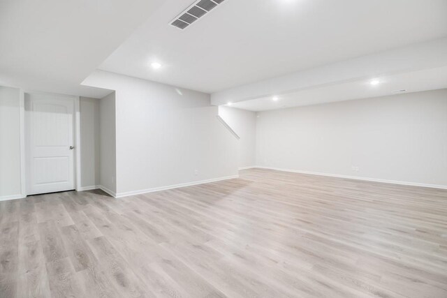 basement with light hardwood / wood-style flooring