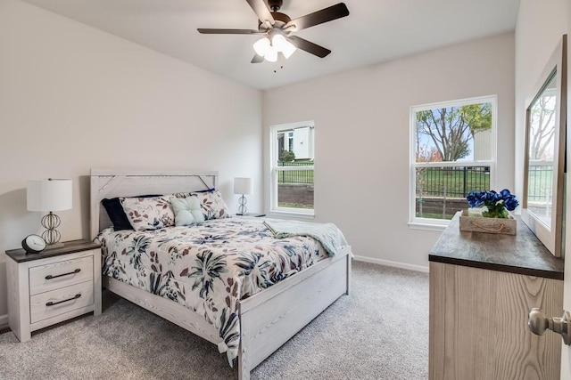 carpeted bedroom featuring multiple windows and ceiling fan