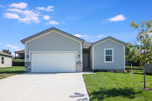 ranch-style house featuring a garage and a front lawn