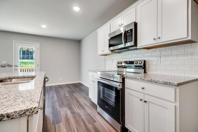 kitchen featuring sink, backsplash, stainless steel appliances, light stone countertops, and white cabinets