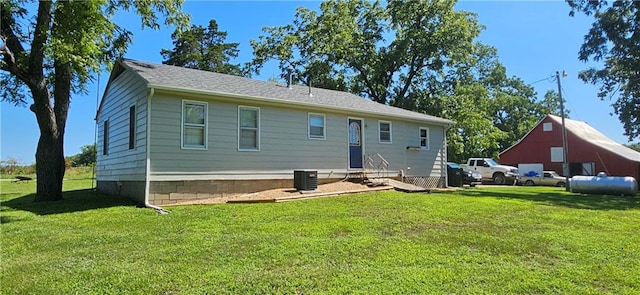 back of house featuring cooling unit and a lawn