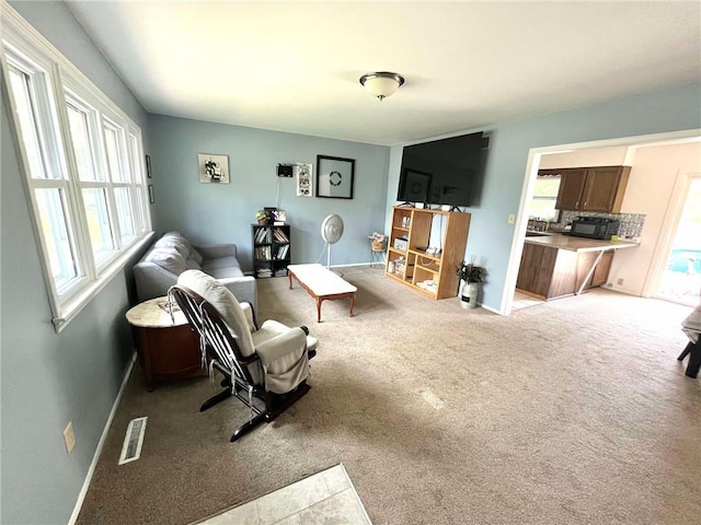 sitting room with baseboards, visible vents, plenty of natural light, and carpet floors