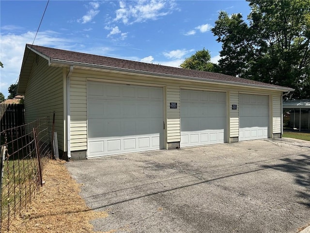 detached garage featuring fence