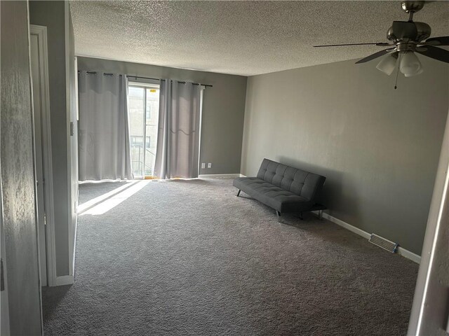 unfurnished room featuring ceiling fan, carpet floors, and a textured ceiling