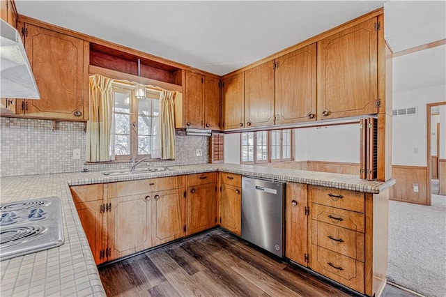 kitchen with dark wood-type flooring, sink, appliances with stainless steel finishes, kitchen peninsula, and extractor fan