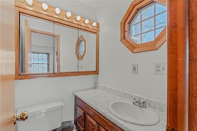 bathroom with plenty of natural light, vanity, and toilet