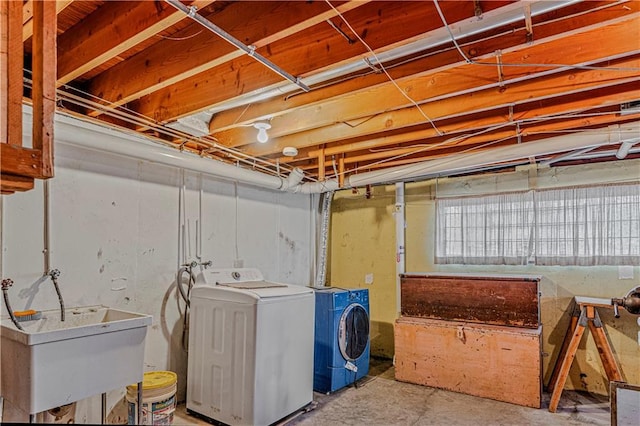 basement featuring washing machine and dryer and sink