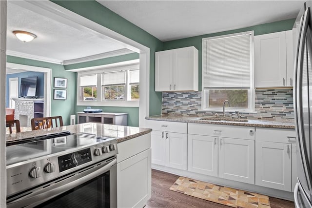 kitchen with appliances with stainless steel finishes, white cabinetry, backsplash, and sink