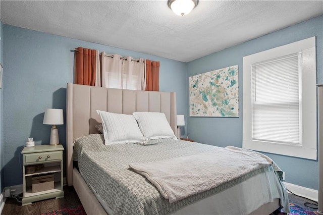 bedroom with dark wood-type flooring and a textured ceiling