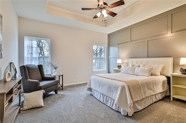 bedroom with carpet, ceiling fan, and a raised ceiling