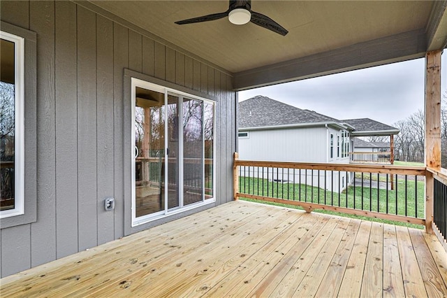 wooden terrace featuring ceiling fan and a lawn