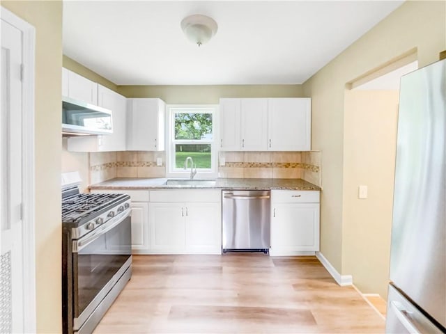 kitchen featuring white cabinets, light wood-type flooring, stainless steel appliances, and sink