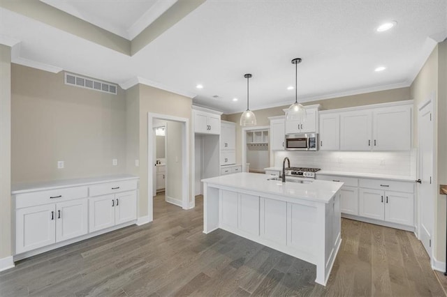 kitchen featuring pendant lighting, white cabinets, stainless steel appliances, and wood-type flooring