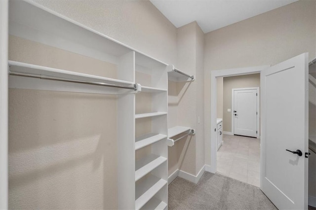 walk in closet with light colored carpet