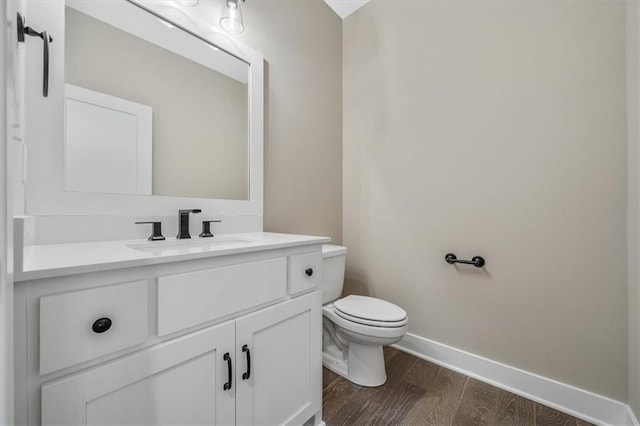 bathroom with hardwood / wood-style flooring, vanity, and toilet