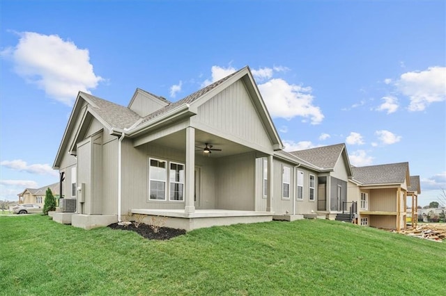 rear view of property with a lawn and ceiling fan