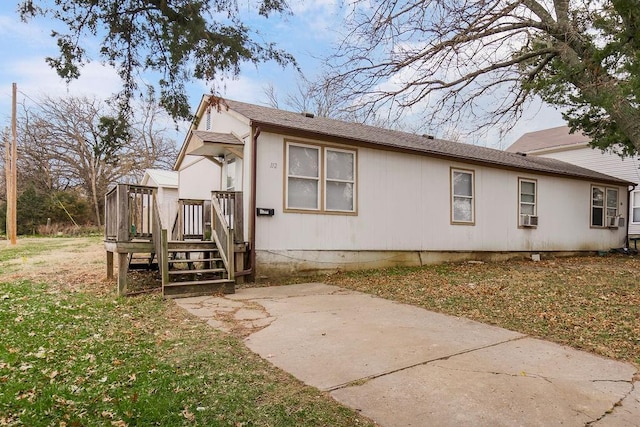 view of side of home featuring a lawn, cooling unit, and a wooden deck