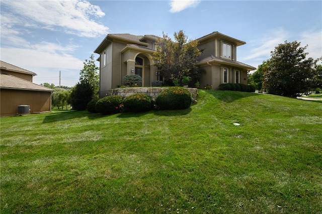 exterior space featuring stucco siding, cooling unit, and a front lawn