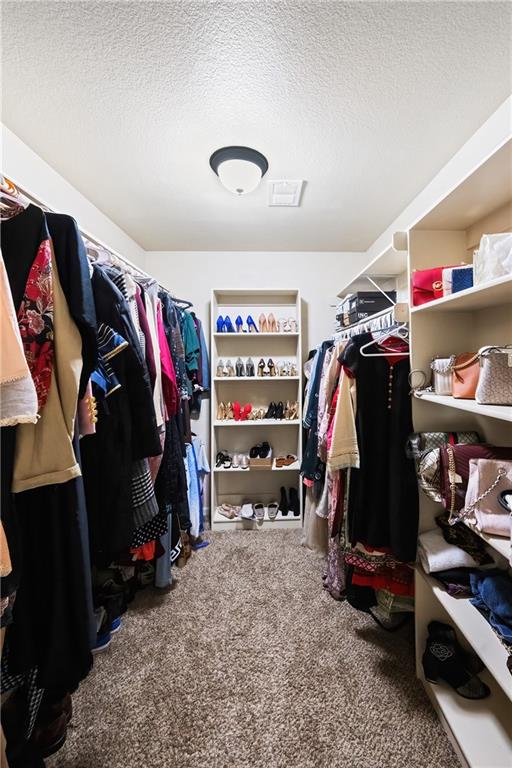 walk in closet featuring carpet flooring