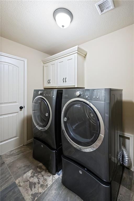 9614 NE 97th St, Kansas City, MO 64157 - laundry room with cabinet space, visible vents, washing machine and clothes dryer, and a textured ceiling