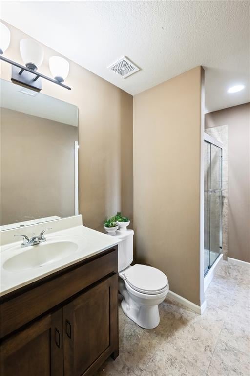 bathroom with vanity, a textured ceiling, toilet, and a shower with door