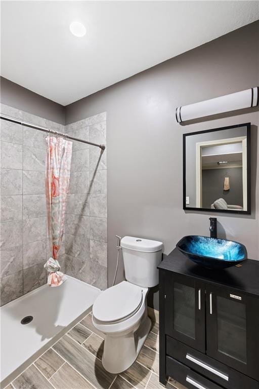 bathroom with walk in shower, vanity, and toilet