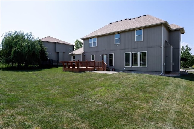 rear view of property with a wooden deck and a yard