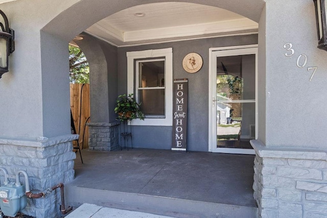 property entrance featuring stone siding and stucco siding