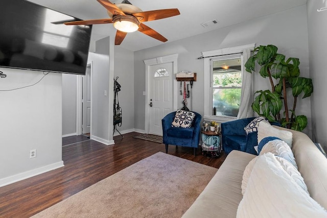 living area with dark wood-style floors, ceiling fan, visible vents, and baseboards